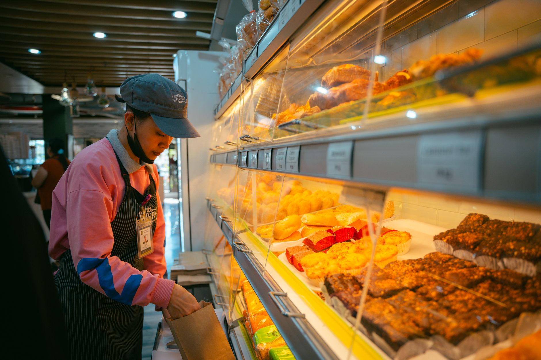 Atendimento em uma confeitaria com bolos na vitrine
