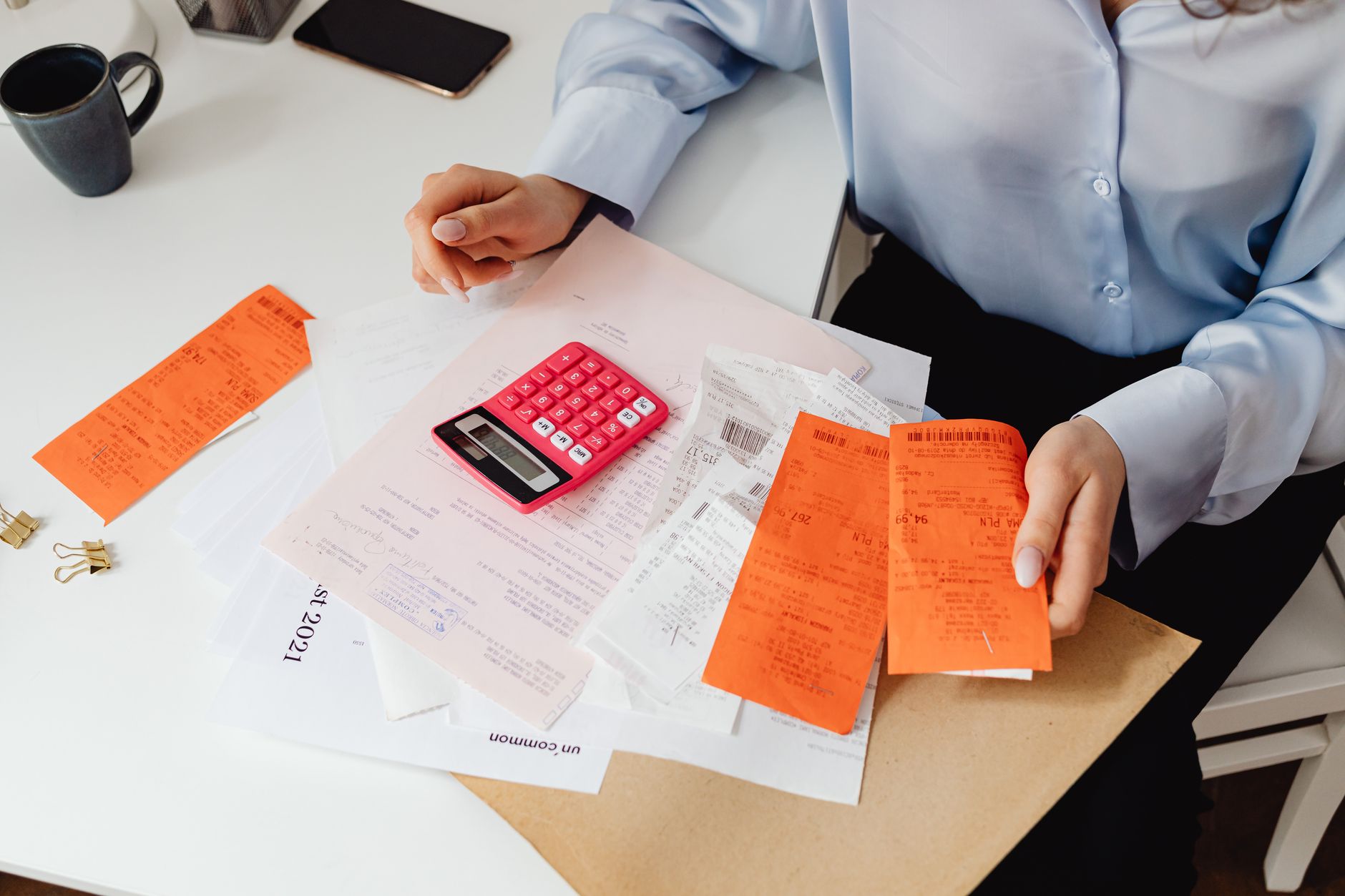 calculadora, boletos e caderno sobre uma mesa
