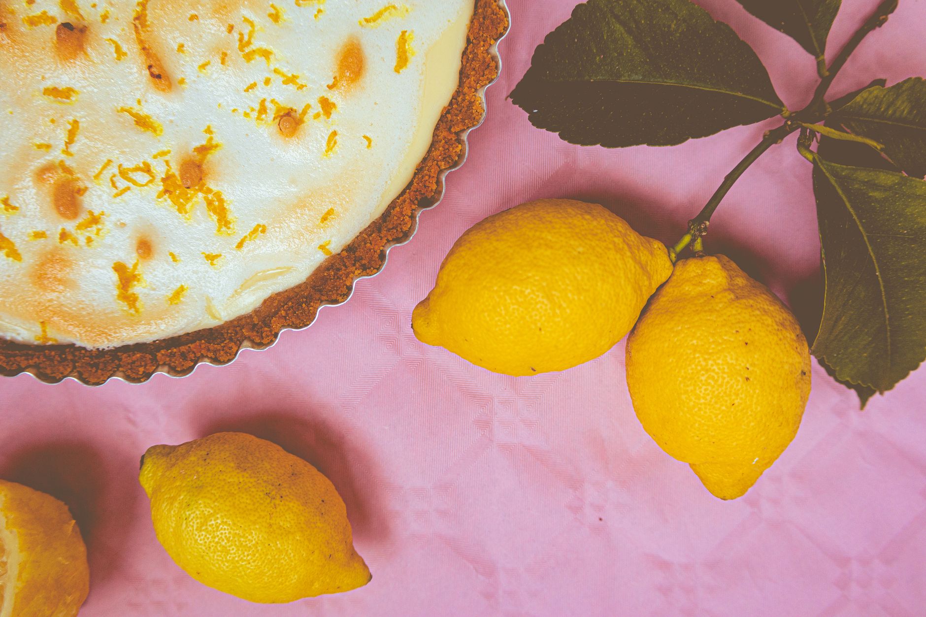 fatia de torta de limão com merengue ao lado da torta inteira